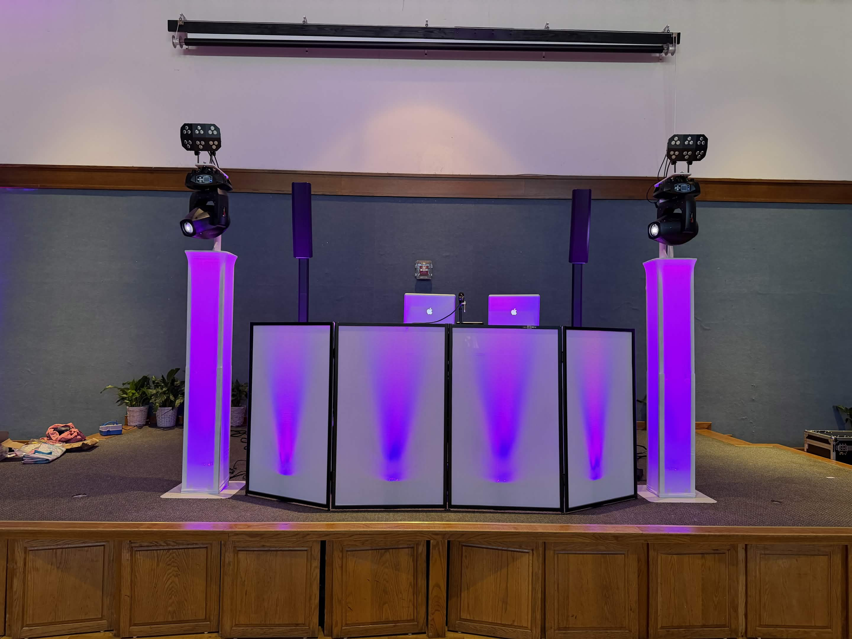 Stage-mounted DJ booth with violet-lit columns and moving lights